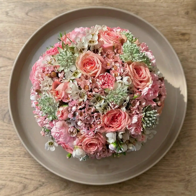 Kugelförmiges Blumengesteck mit dichter Blütenstruktur – florale Gestaltung in klarer Form