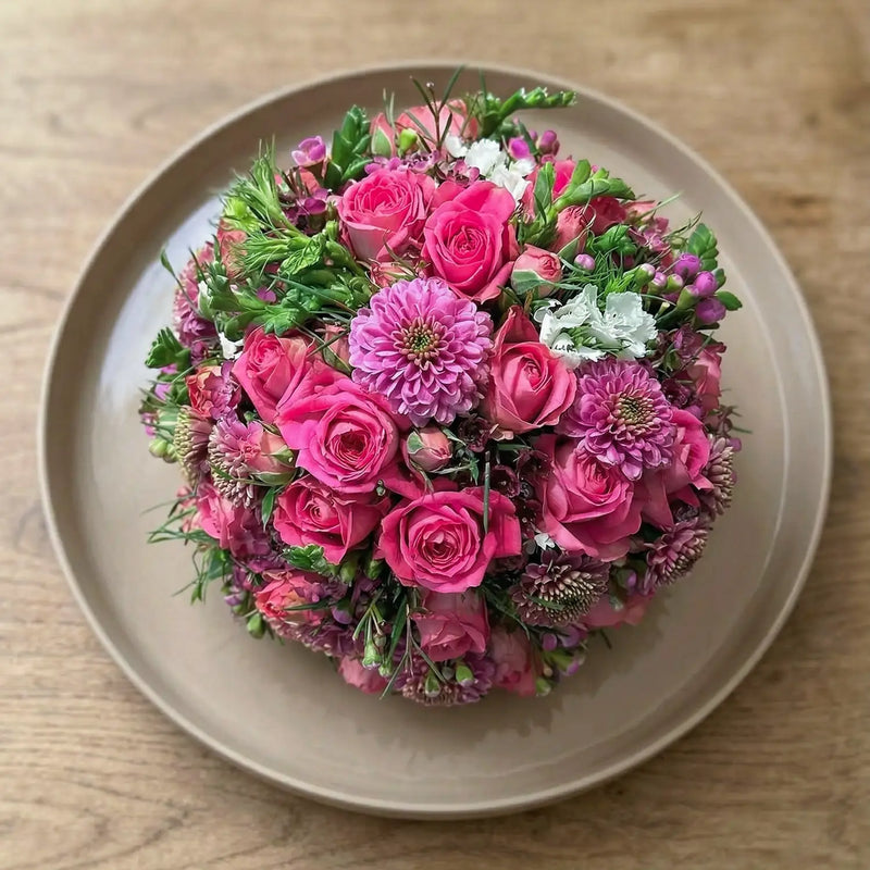 Kugelförmiges Blumengesteck mit dichter Blütenstruktur – florale Gestaltung in klarer Form