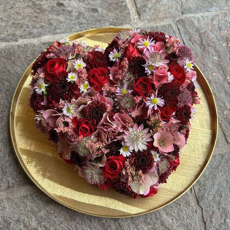 Herzförmiges Blumengesteck mit natürlichem Aufbau – florale Gestaltung von DADA Dornbirn von der Seite
