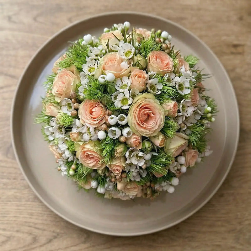 Kugelförmiges Blumengesteck mit dichter Blütenstruktur – florale Gestaltung in klarer Form