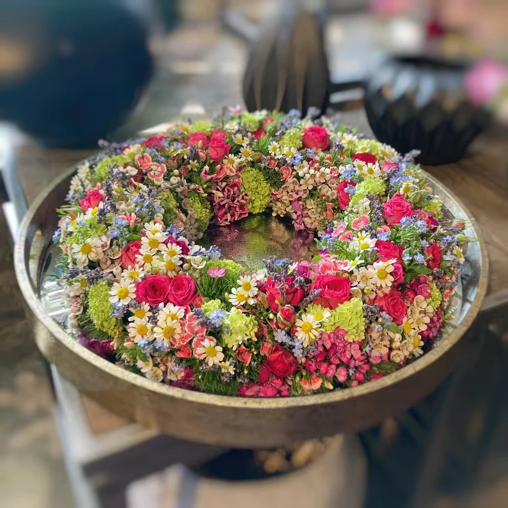 Kreisförmiger Blumenkranz mit dichter Blütenstruktur – florale Gestaltung mit zeitloser Anmutung