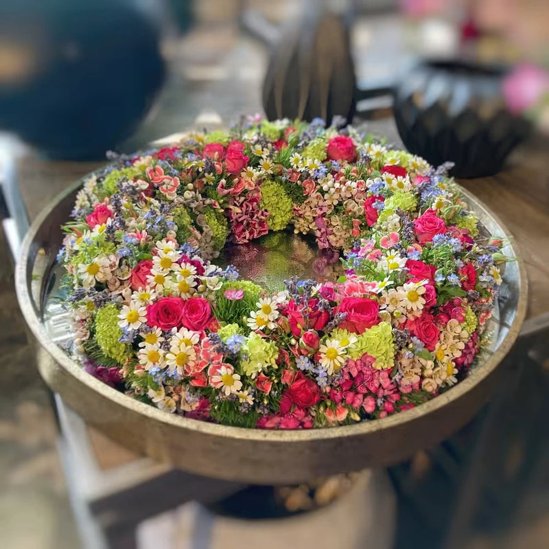 Kreisförmiger Blumenkranz mit dichter Blütenstruktur – florale Gestaltung mit zeitloser Anmutung