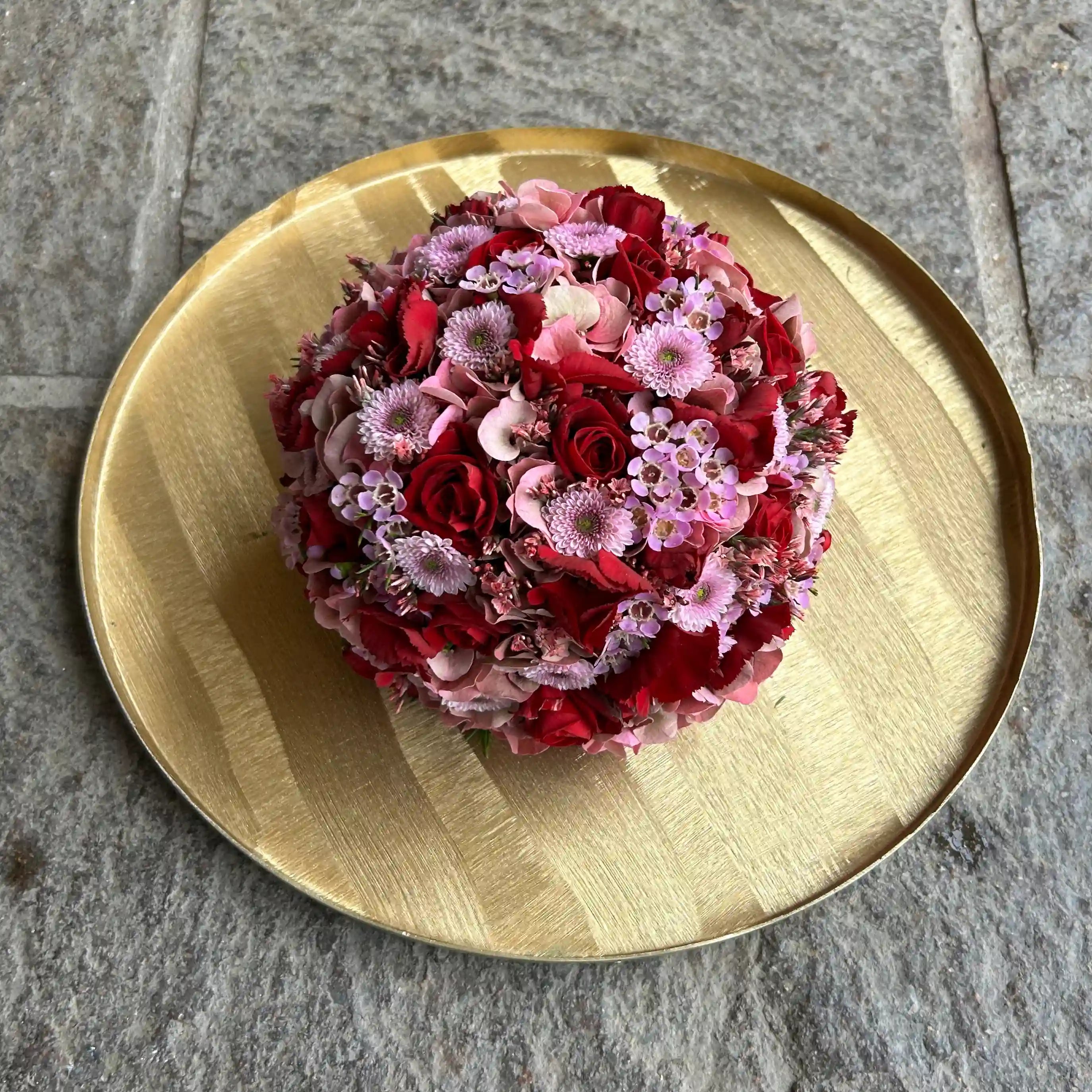 Kugelförmiges Blumengesteck mit dichter Blütenstruktur – florale Gestaltung in klarer Form
