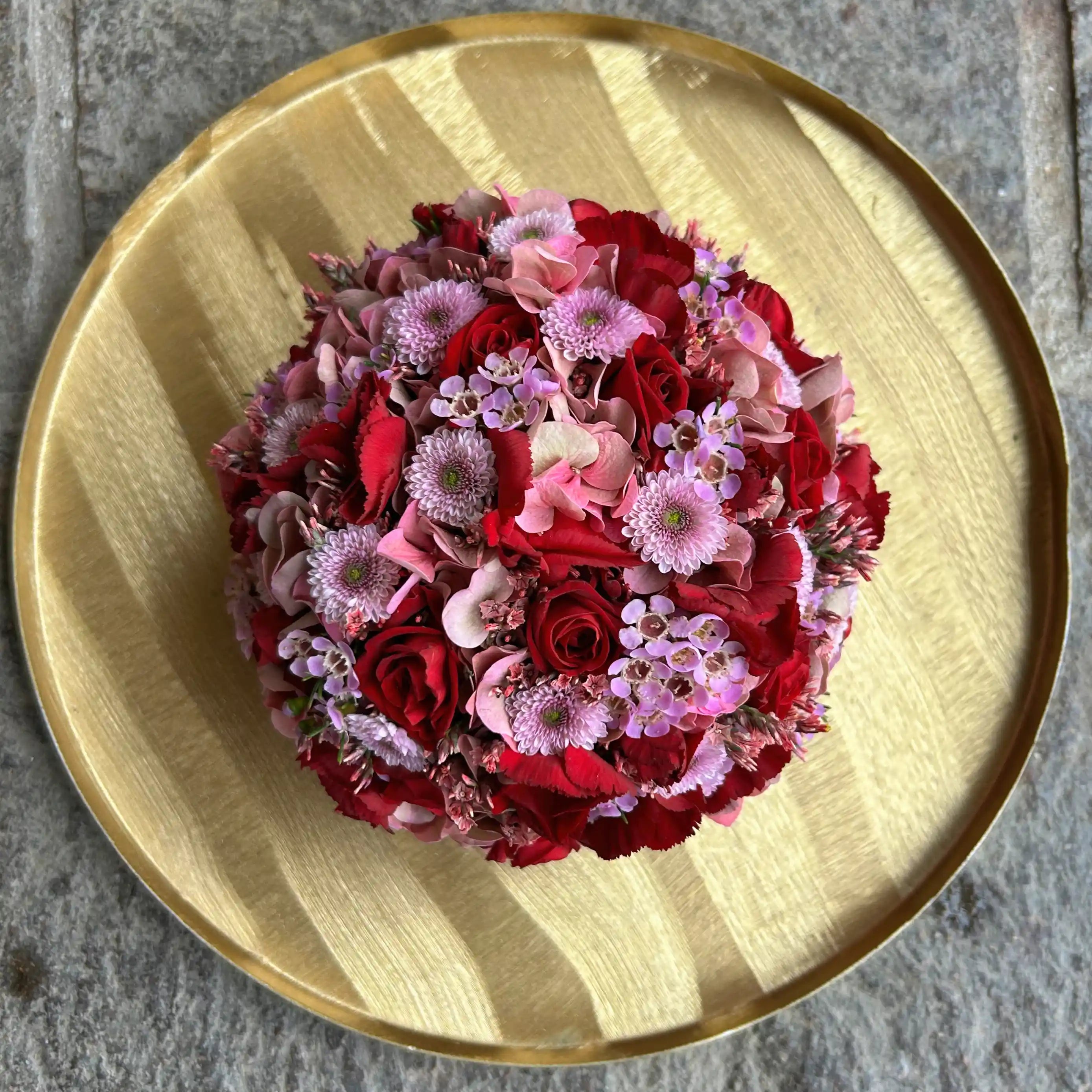 Kugelförmiges Blumengesteck mit dichter Blütenstruktur – florale Gestaltung in klarer Form von oben 