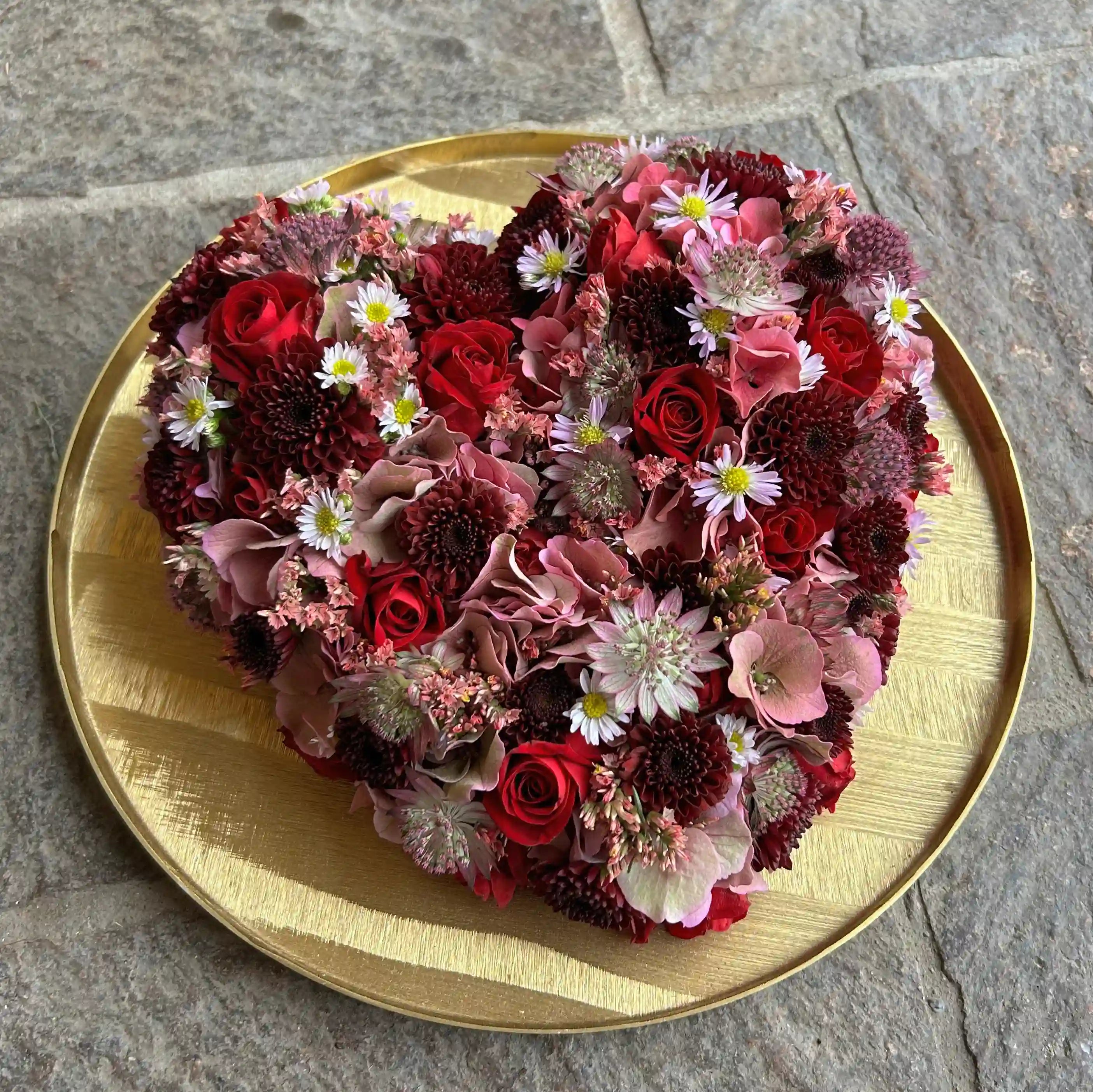 Herzförmiges Blumengesteck mit natürlichem Aufbau – florale Gestaltung von DADA Dornbirn von der Seite
