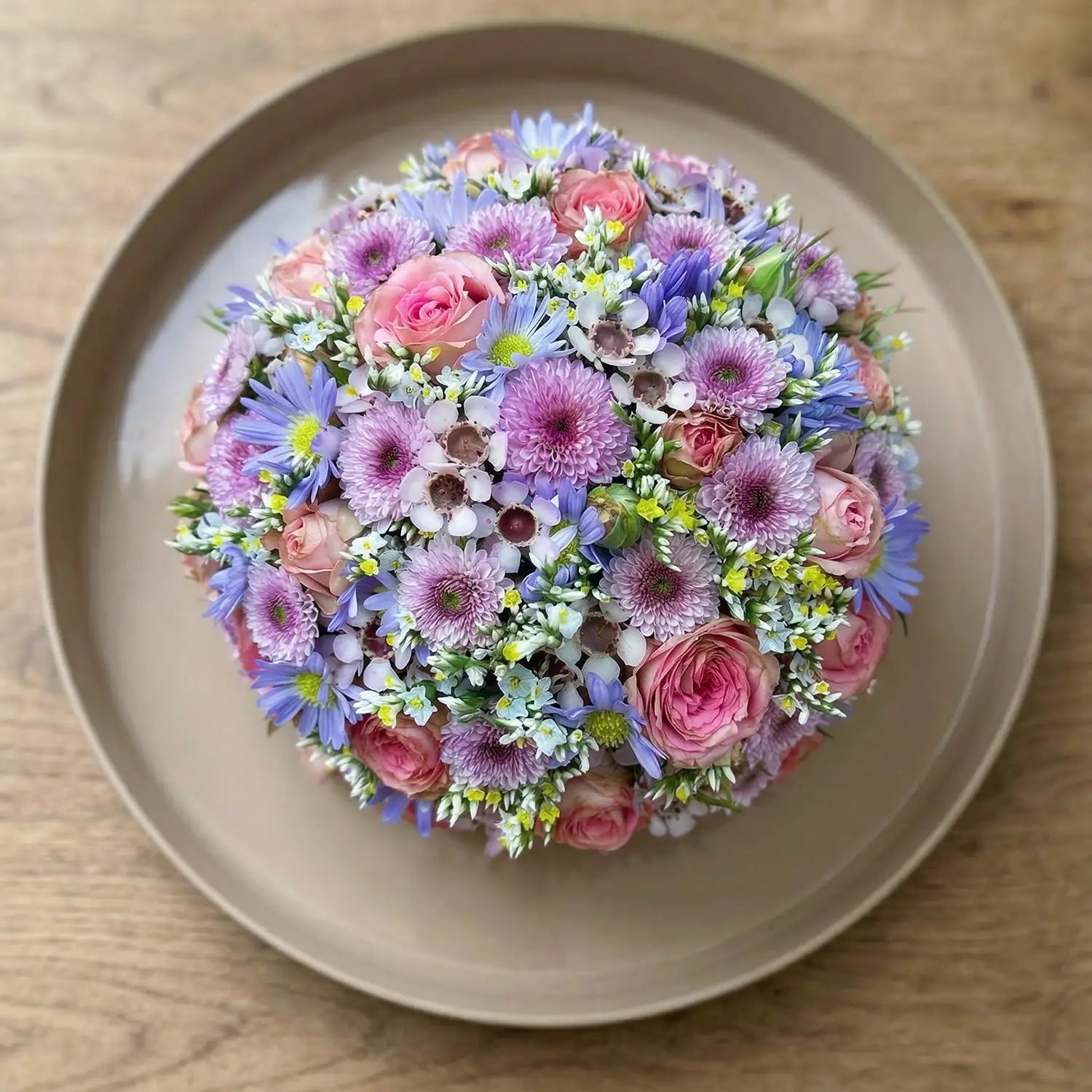 Kugelförmiges Blumengesteck mit dichter Blütenstruktur – florale Gestaltung in klarer Form